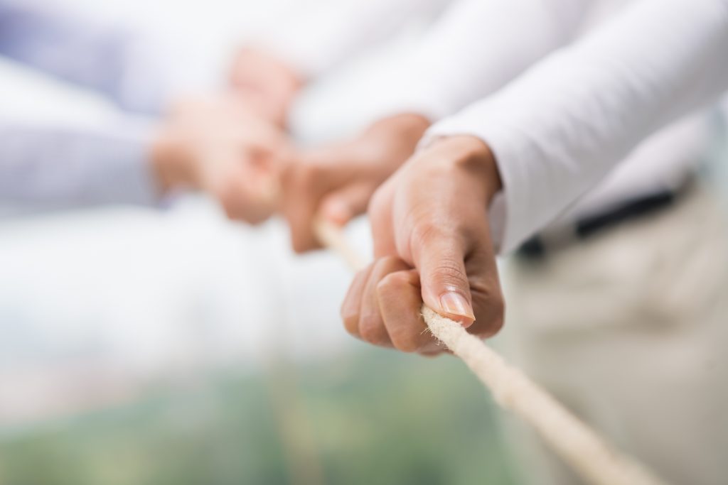 Concept image of business team using a rope as an element of the teamwork on the foreground